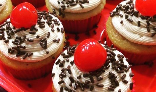 Root beer float cupcake with chocolate sprinkles and a maraschino cherry